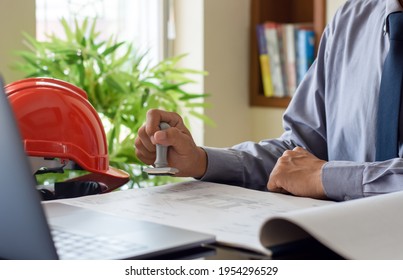 Architect man or male engineer hand stamping rubber stamper on  blueprint paperwork at office. Authorized allowance permission approval concept. - Shutterstock ID 1954296529