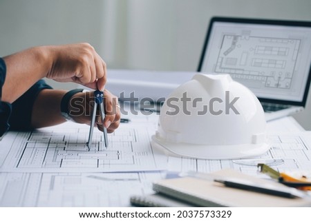 Architect man sketching architectural project on blueprint, Architecturalengineering concept
