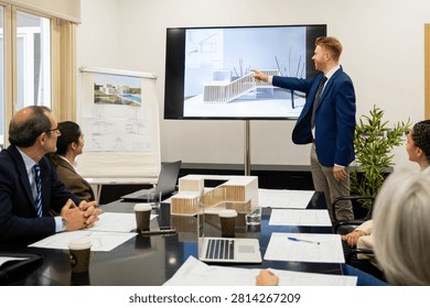 Architect presenting building project design to clients in an office meeting