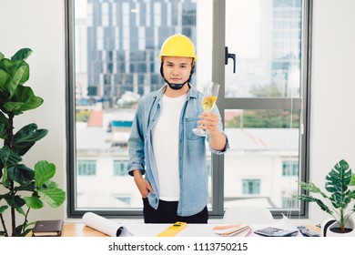 Architect Sketching Construction Project On Wooden Table,holding Glasses Champange