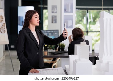 Architect Taking Building 3d Printed Model Photo, Working With City Construction Project In Architecture Office. Asian Employee Engineering In Coworking Space, Real Estate Agency Worker