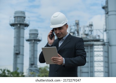 Architect Talking On Phone On Power Plant Bacground. Portrait Of A Engineer. Portrait Of A Businessman. Construction Workers, Engineer Hand Hold Drawing On Power Plant On Background.