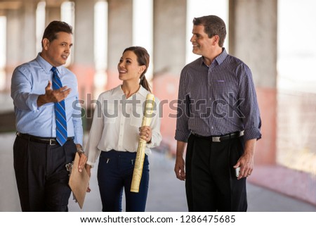 An architect and two executives talk on construction site.