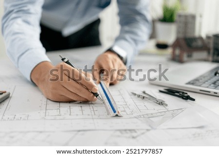 Architect use compasses for design drawing draft circles sketch on blueprints in the office, working with modern house blueprint floorplans, creative, architectural and construction project concepts.
