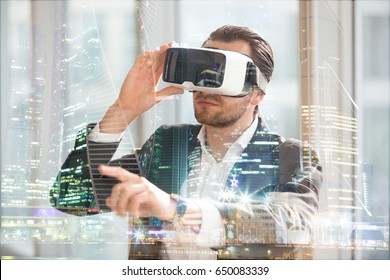 Architect in VR glasses working in augmented reality of city space. Man wearing virtual reality glasses, pointing at digitally simulated urban view. Businessman in 3d goggles interacts with cyberspace - Powered by Shutterstock