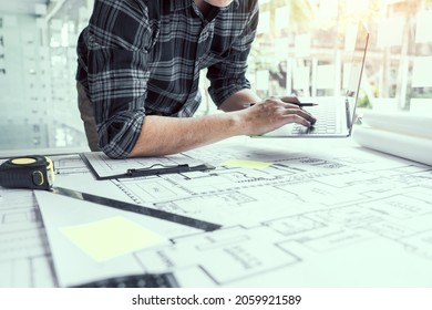 Architect working new project and using laptop with in office.