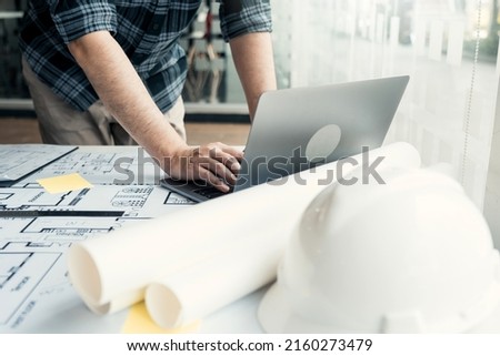 Architect working new project and using laptop with in office.