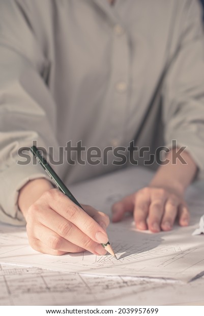Architect working on blueprint. Architects
workplace - architectural project, blueprints, ruler, calculator,
laptop and divider compass. Construction concept. Blue print is
fake only for stock
photo.