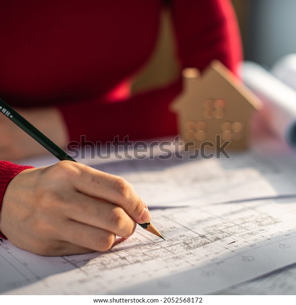 Architect working on blueprint. Architects\
workplace - architectural project, blueprints, ruler, calculator,\
laptop and divider compass. Construction concept. Blue print is\
fake only for stock\
photo.