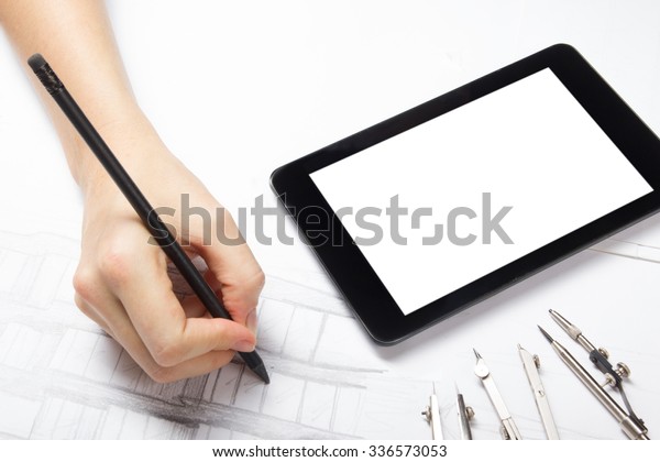 Architect working on blueprint. Architects\
workplace - architectural project, blueprints, pencil, blank tablet\
pc and divider compass. Construction concept. Engineering tools.\
Cope space for text.