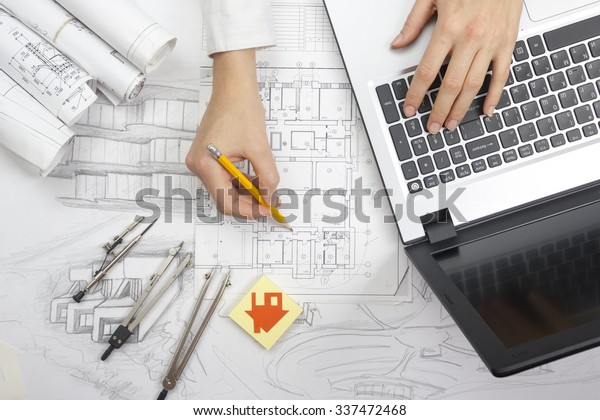 Architect working on\
blueprint. Architects workplace - architectural project,\
blueprints, laptop and divider compass, pencil. Construction\
concept. Engineering tools. Top\
view