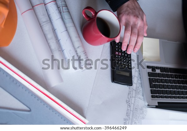 Architect working on blueprint. Architects workplace
- architectural project, blueprints, ruler, calculator, laptop and
divider compass. Construction concept. Engineering tools. Top
view