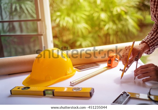 Architect working on blueprint. Architects\
workplace - architectural project, plan,,\
sketch