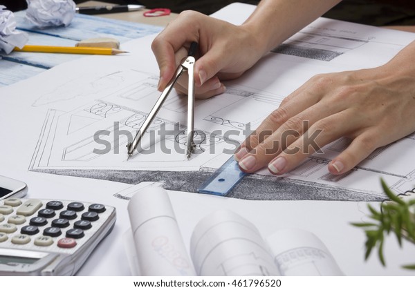 Architect working on blueprint. Architects\
workplace - architectural project, blueprints, ruler, calculator,\
laptop and divider compass. Construction concept. Engineering\
tools. Top view.