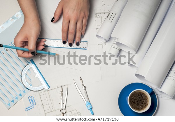 Architect working on\
blueprint. Architects workplace - architectural project,\
blueprints, ruler and divider compass. Construction concept.\
Engineering tools. Top\
view