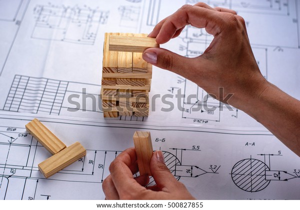 Architect working on\
blueprint. Architects workplace - architectural project,\
blueprints, laptop and divider compass, pencil. Construction\
concept. Engineering\
tools