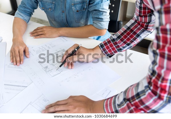 Architect working on blueprint,\
Engineer meeting working with partner colleagues and engineering\
tools for architectural project, Construction\
concept.
