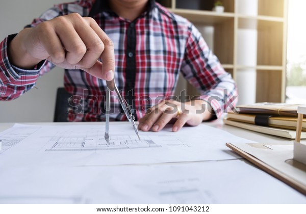 Architect working on
blueprint, Engineer working with engineering tools for
architectural project on
workplace.