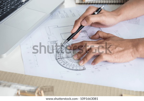 Architect
working on blueprint, Engineer working with engineering tools for
architectural project on workplace, Construction concept - building
project, blueprints, ruler and
dividers.