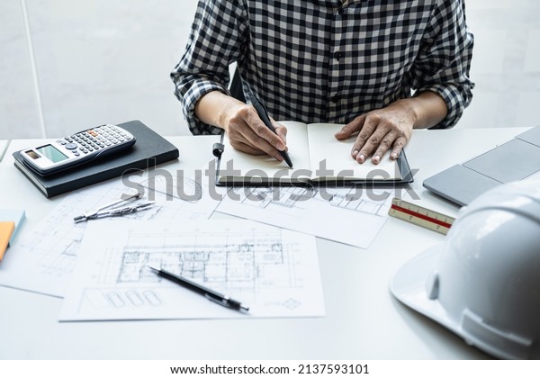 Architect\
working on blueprint, Engineer working with engineering tools for\
architectural project on workplace, Construction concept - building\
project, blueprints, ruler and\
dividers.