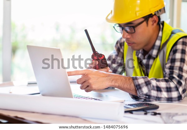 Architect working on blueprint.engineer inspective\
in workplace - architectural project,\
blueprints,ruler,calculator,laptop and divider compass.\
Construction concept, selective\
focus
