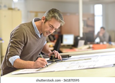 Architect Working On Drawing Table In Office