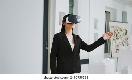 Architect working on new project with vr headset in office, developing industrial plan to remodel building property at unicorn business agency. Woman using virtual reality metaverse tech. - Powered by Shutterstock