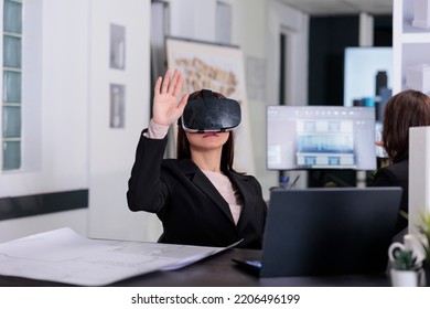 Architect Working On Project Blueprints Wearing Vr Helmet In Architecture Office. Employee Engineering And Using Virtual Reality Headset, Real Estate Agency Worker In Ar Goggles.