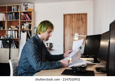 Architect Working On Project In Office. Architect Working With Blueprints. Young Man With Green Hair.