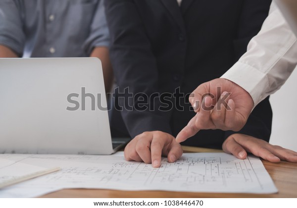 architect working on real estate project with
partner at workplace. engineer discussing with colleague on living
house blueprint at office. Business, people, construction and
building concept