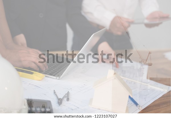 architect working on real estate project with\
partner at workplace. engineer discussing with colleague on living\
house blueprint at office. Business, people, construction and\
building concept