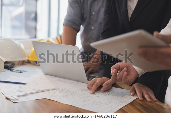 architect working on real estate project with
partner at workplace. engineer discussing with colleague on living
house blueprint at office. Business, people, construction and
building concept