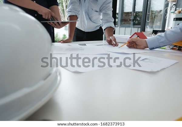 architect working on\
real estate project with partner at workplace. engineer discussing\
with colleague on living house blueprint at office. construction\
& building\
concept