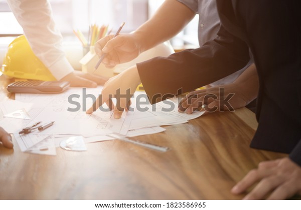 architect working on real estate project with\
partner at workplace. engineer discussing with colleague on living\
house blueprint at office. Business, people, construction and\
building concept