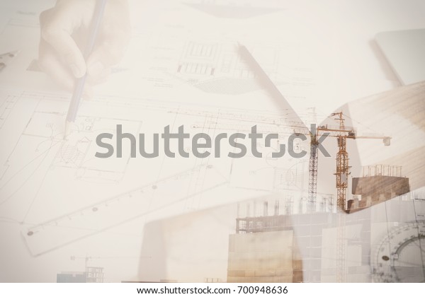 architect working on real estate project at\
workplace. Male engineer hand working with living house blueprint\
at office. Business, people, construction and building concept\
double exposure with\
crane
