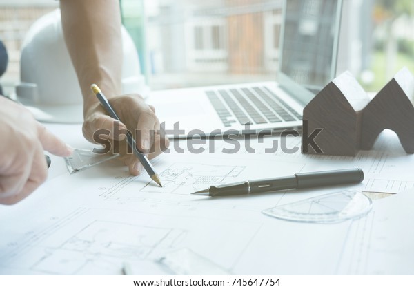 architect working on real estate project with partner at\
workplace. Male engineer hand discussing with colleague on living\
house blueprint at office. Business, people, construction and\
building 