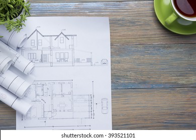 Architect worplace top view. Architectural project, blueprints, blueprint rolls and  divider compass, calipers on vintage wooden desk table. Construction background. Engineering tools. Copy space - Powered by Shutterstock