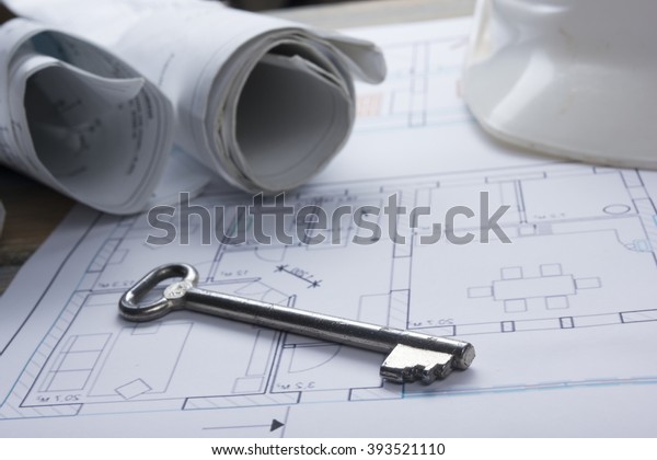 Architect worplace top view. Architectural project,
blueprints, blueprint rolls and  divider compass, key, blank
business card on plans. Construction background. Engineering tools.
Copy space