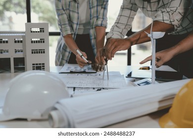 Architects collaborate on sustainable building project, using compass to plan with precision. Teamwork and innovation in architecture - Powered by Shutterstock