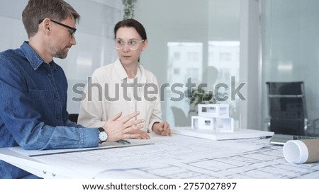 Architects collaborating on architectural project, discussing building design plans, creating new house models, developing urban construction schemes, working in modern office