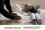 Architects concept, engineer architect designer freelance work on start-up project drawing, construction plan architect design working drawing sketch plans blueprints and making construction model