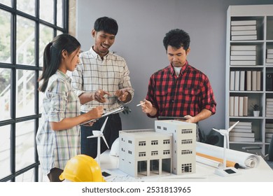 Architects are discussing a project using a model of a building and digital tablet