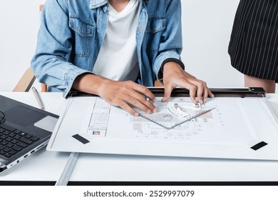 Architects are drafting plans for rooftop solar installation project. Architects are drafting and using many tools on the architect's desk to draft construction plans.