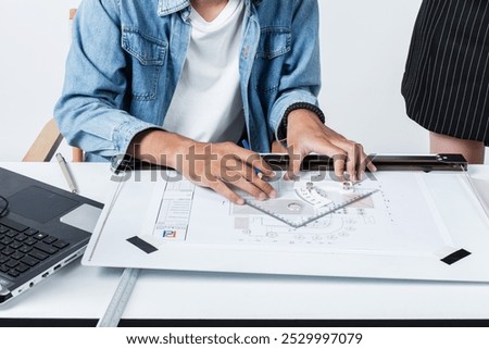 Architects are drafting plans for rooftop solar installation project. Architects are drafting and using many tools on the architect's desk to draft construction plans.