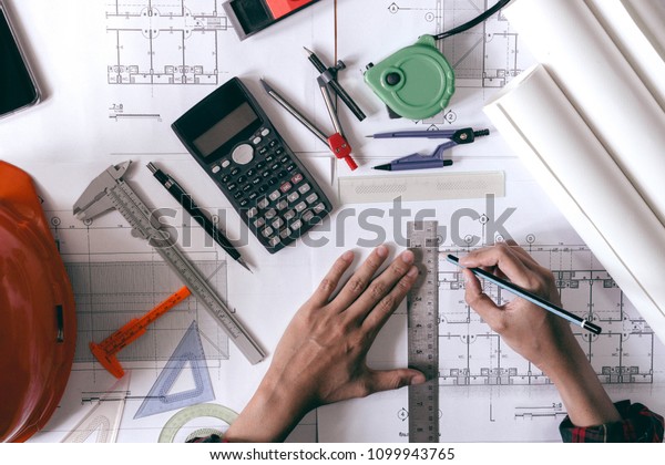 Architects\
is drawing blueprints for home\
construction.
