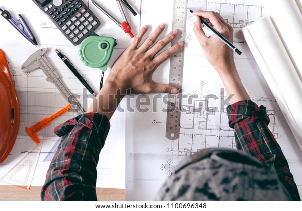 Architects\
is drawing a blueprints for home\
construction.