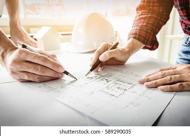 Architects engineer discussing at the table with blueprint - Closeup on hands and project print - Shutterstock ID 589290035