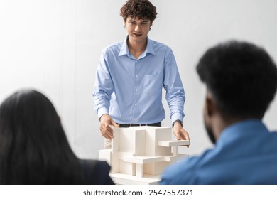 Architects engineers collaborating on building design project in modern office, diverse team of professionals female muslim architect and male engineers discussing architectural model of structure - Powered by Shutterstock