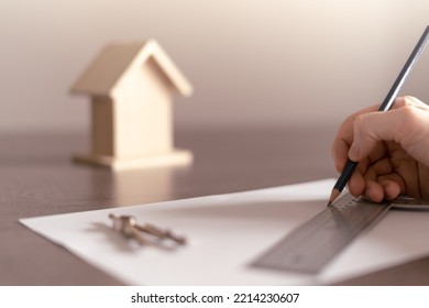 Architect's hand drawing the sketch for the construction project of a house for a client. - Shutterstock ID 2214230607