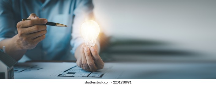 Architects holding light bulbs, Creative new idea. Innovation, finding ideas to design creative and correct houses according to principles. Interior design ideas. - Shutterstock ID 2201238991